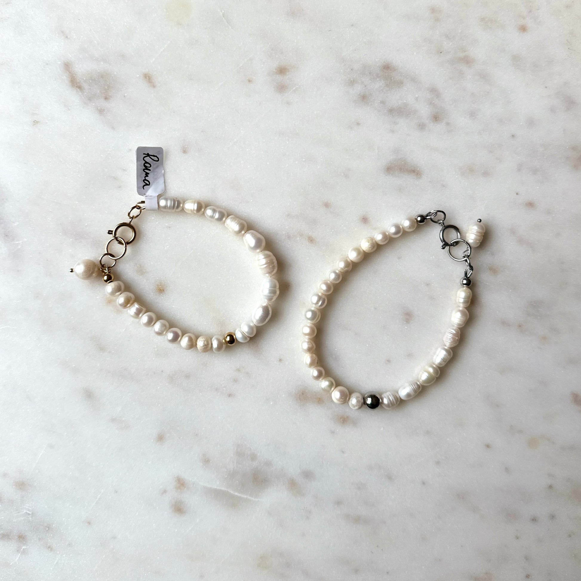 Pearl bracelet on a marble surface with silver and gold accents