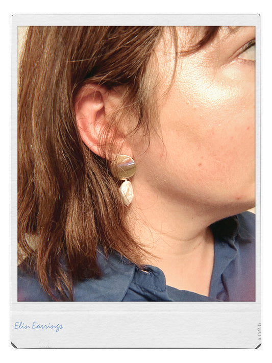 Close-up of a person wearing earrings with a blurred background
