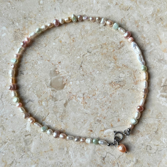 Pearl necklace on a textured stone surface