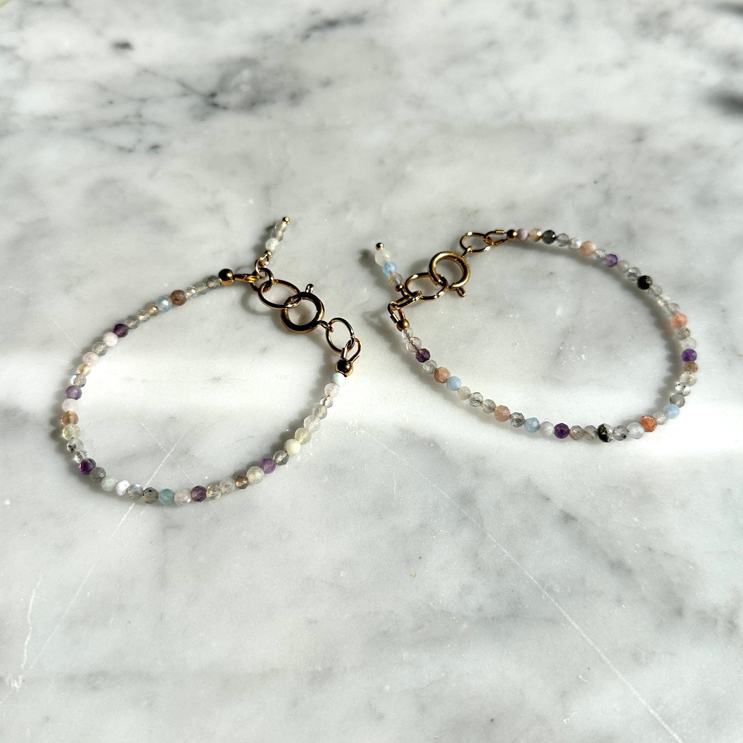 Two beaded bracelets on a marble surface