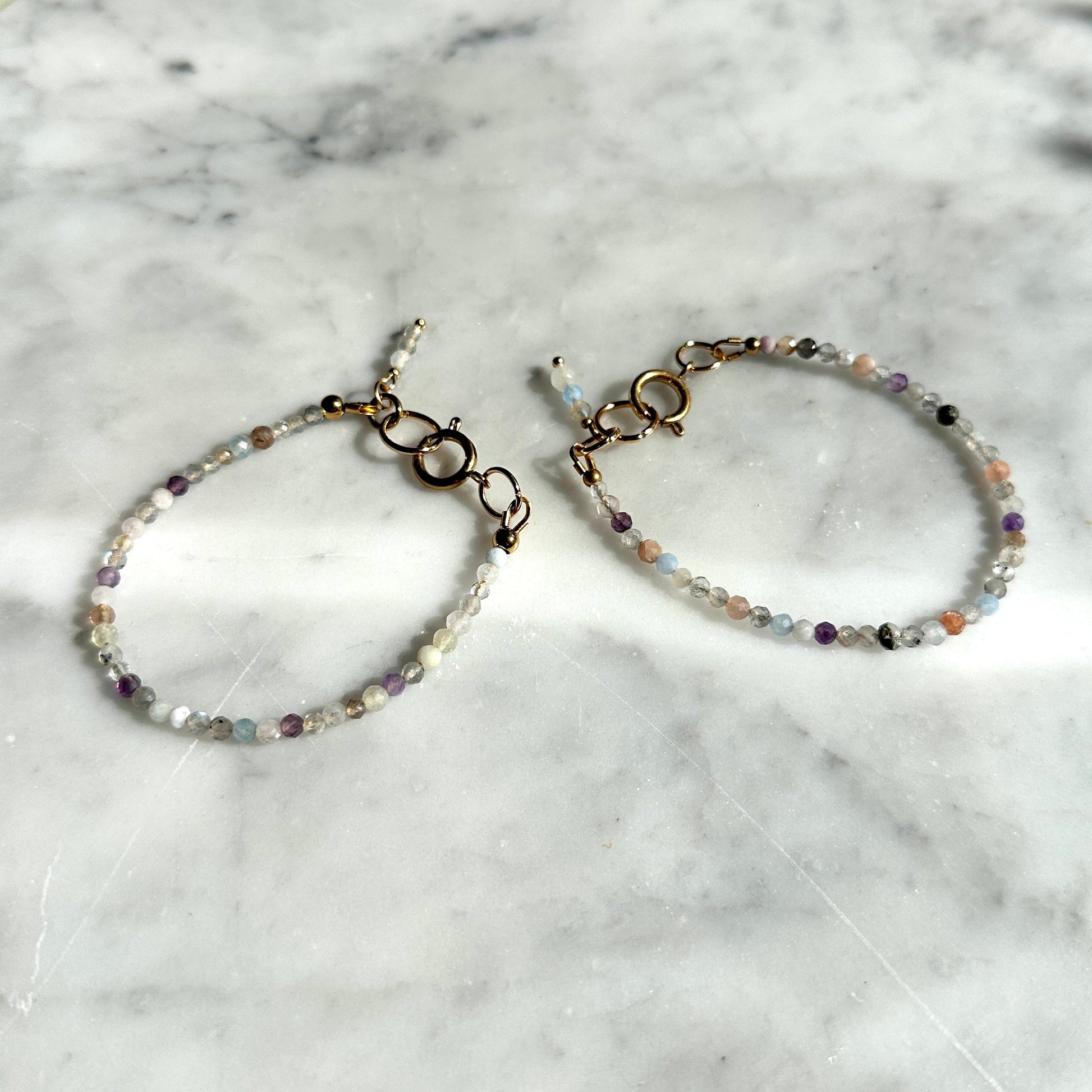 Two beaded bracelets on a marble surface