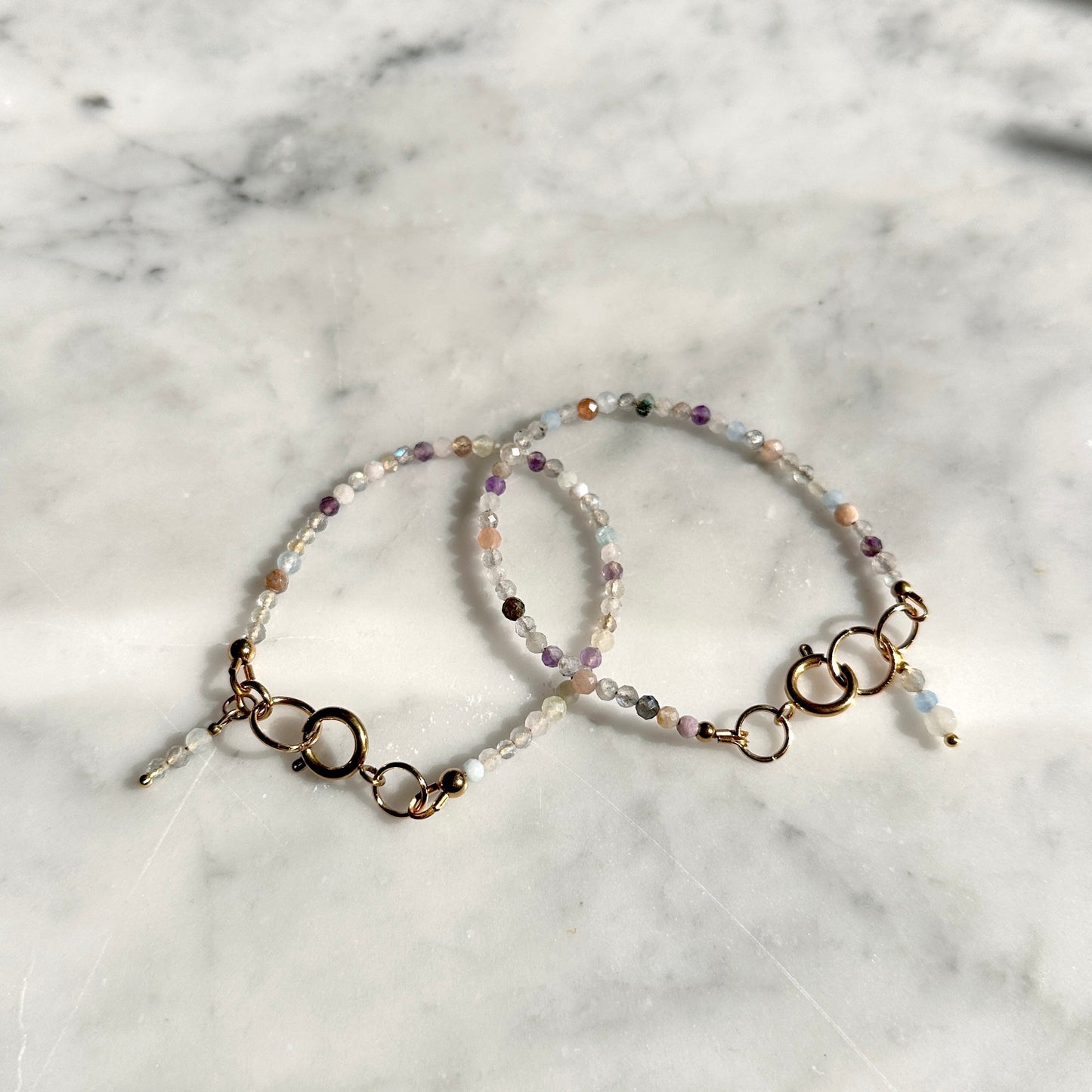 Two beaded bracelets on a marble surface