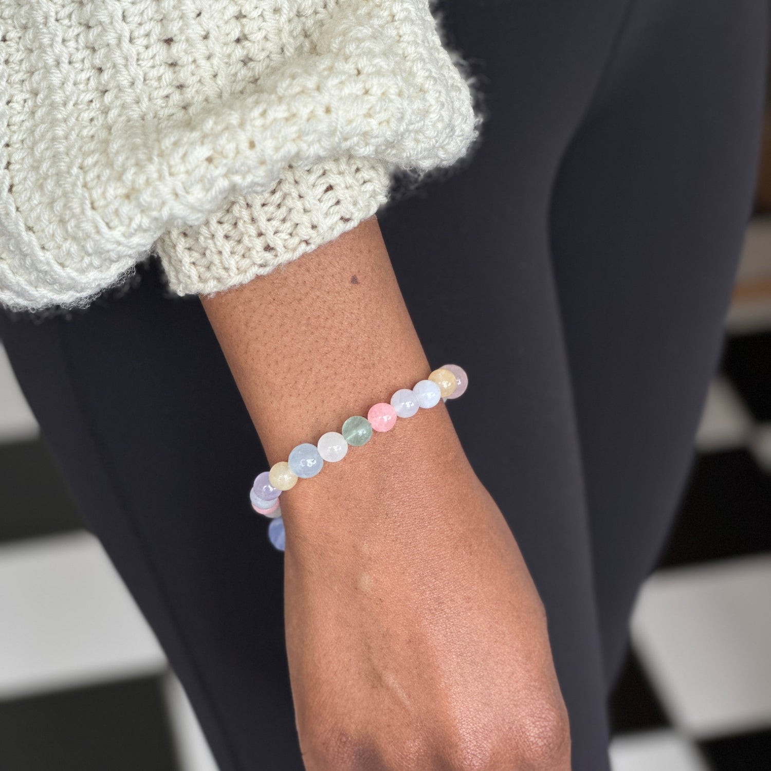 person wearing handmade stone colorful bracelet made of jade, agate, quartz