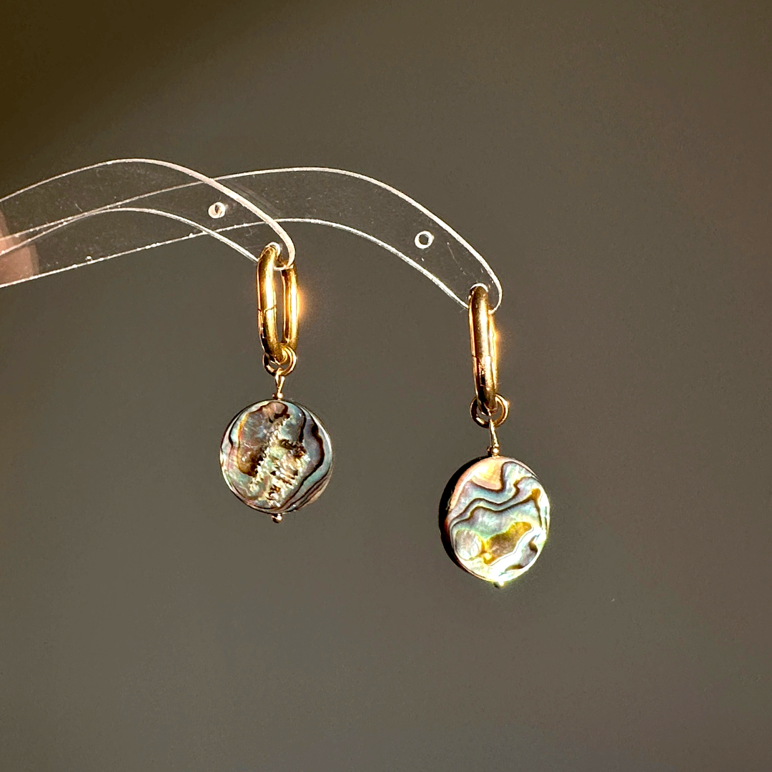handmade earrings of abalone shell shining in the sun 