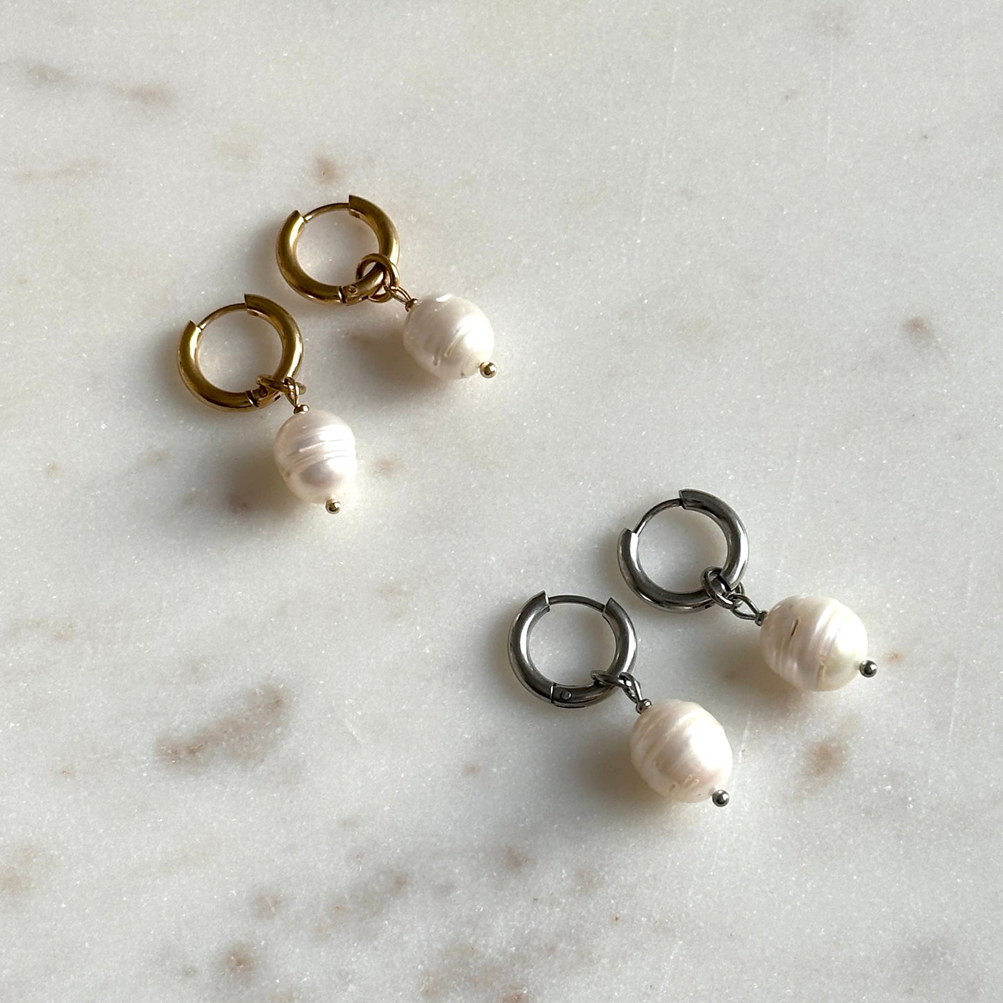 Pair of pearl earrings on a marble surface