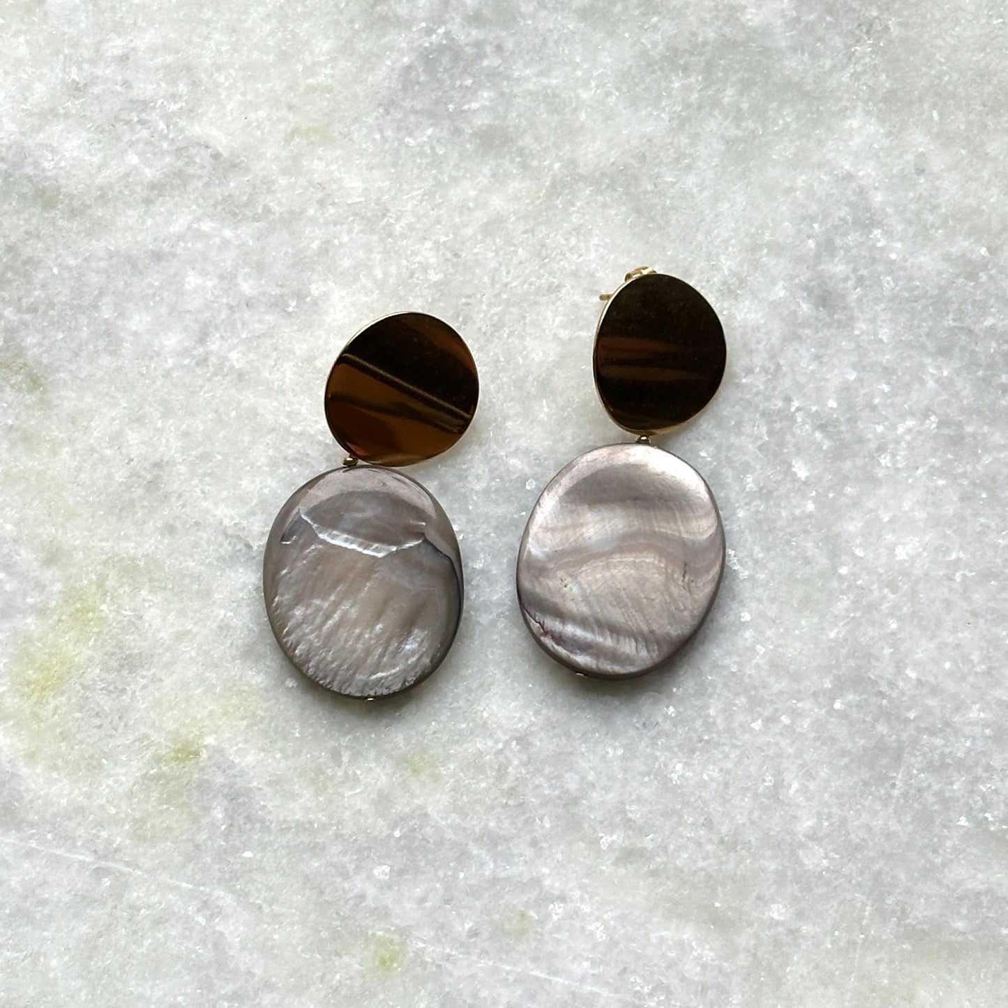 A pair of earrings with mother-of-pearl pendants.