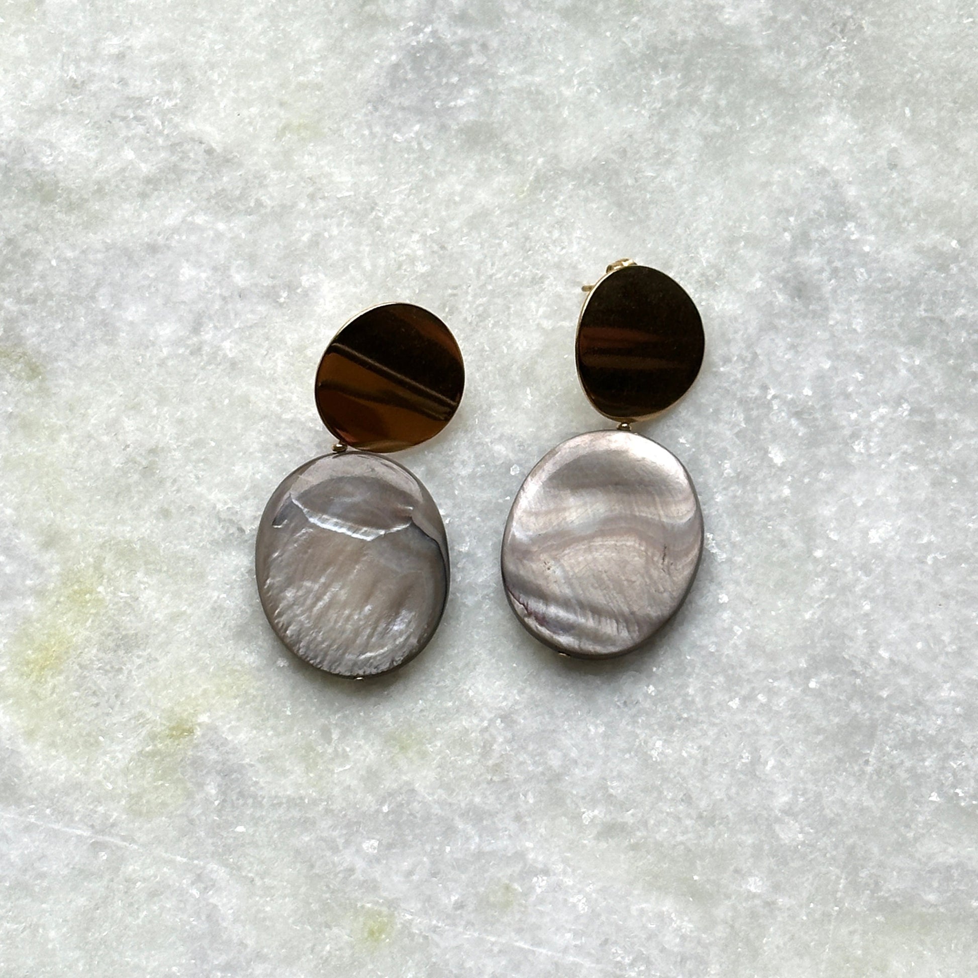 A pair of earrings with mother-of-pearl pendants.