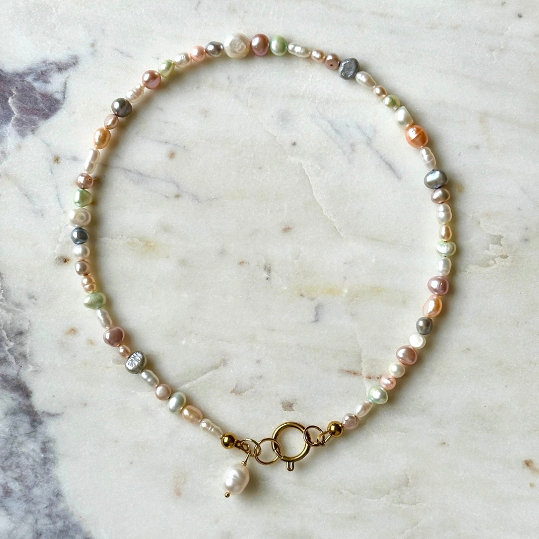 Pearl bracelet with gold clasp on a marble surface