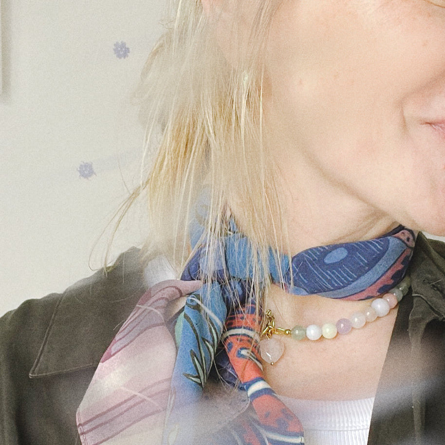 Person wearing a colorful scarf with a neutral background