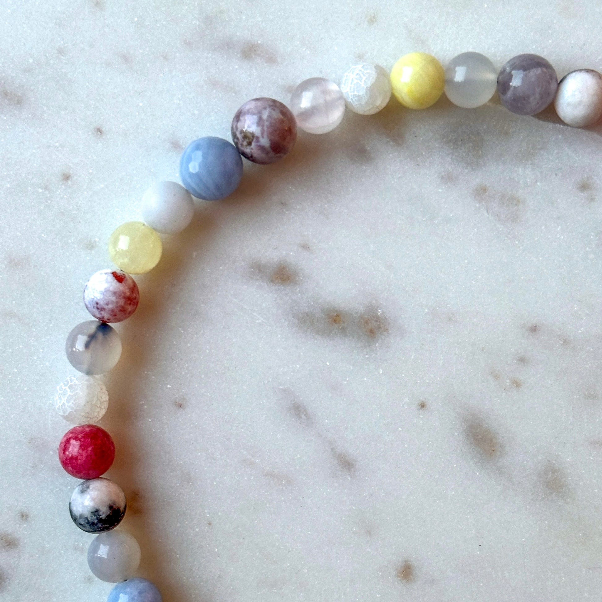 Multicolored beaded necklace on a marble surface