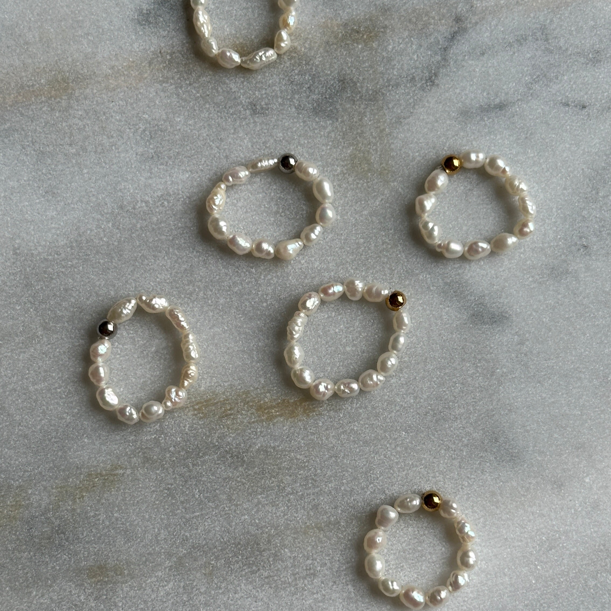 Set of pearl rings on a marble surface